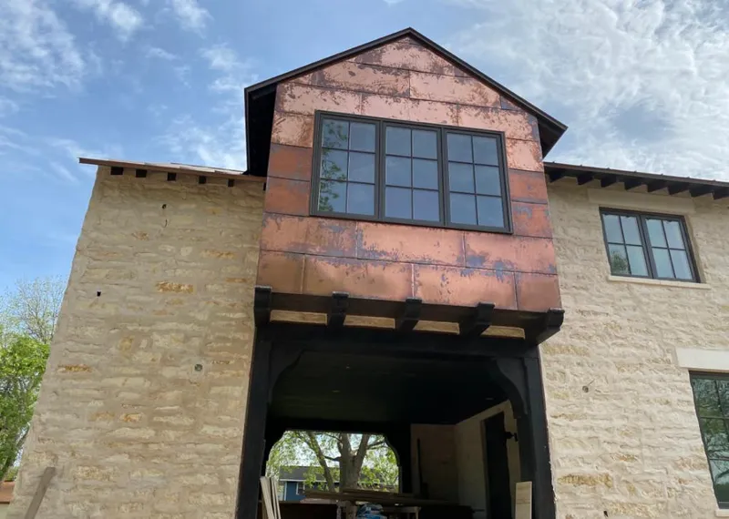 Copper metal panel facade on a stone building for Skylight Installation in Stillwater